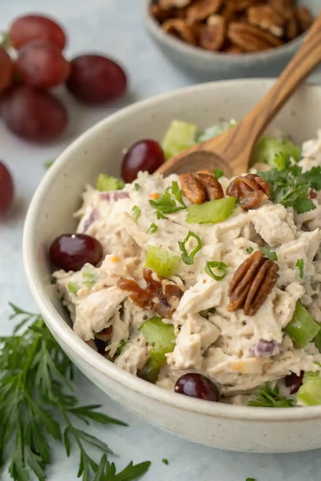 Newks Chicken Salad Recipe,Newk's Chicken Salad,Newk’s Chicken Salad Recipe,Homemade Newk’s Chicken Salad Close-up of creamy Newk’s chicken salad with shredded chicken, grapes, celery, and pecans served in a bowl with a wooden spoon.